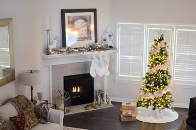 带灯串的圣诞树在房间内的电壁炉附近打开